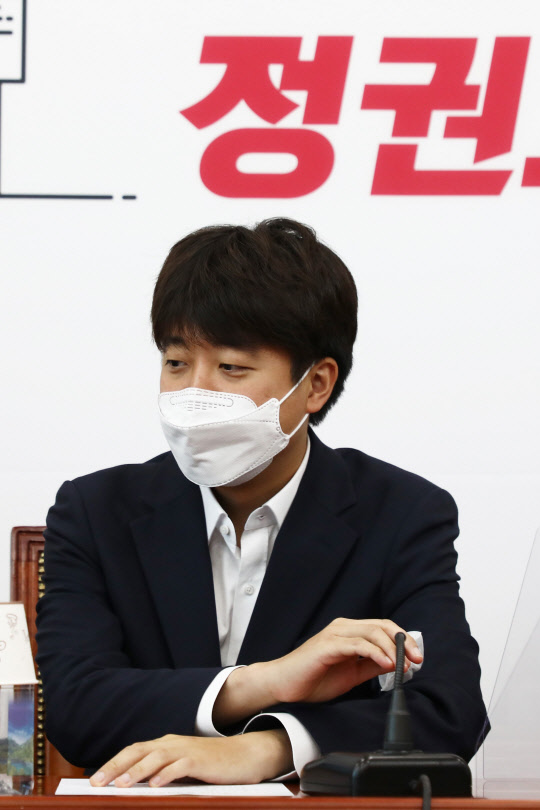 이준석 국민의힘 대표가 19일 서울 여의도 국회에서 열린 최고위원회의에서 공개발언을 생략하고 마이크를 내리고 있다.연합뉴스